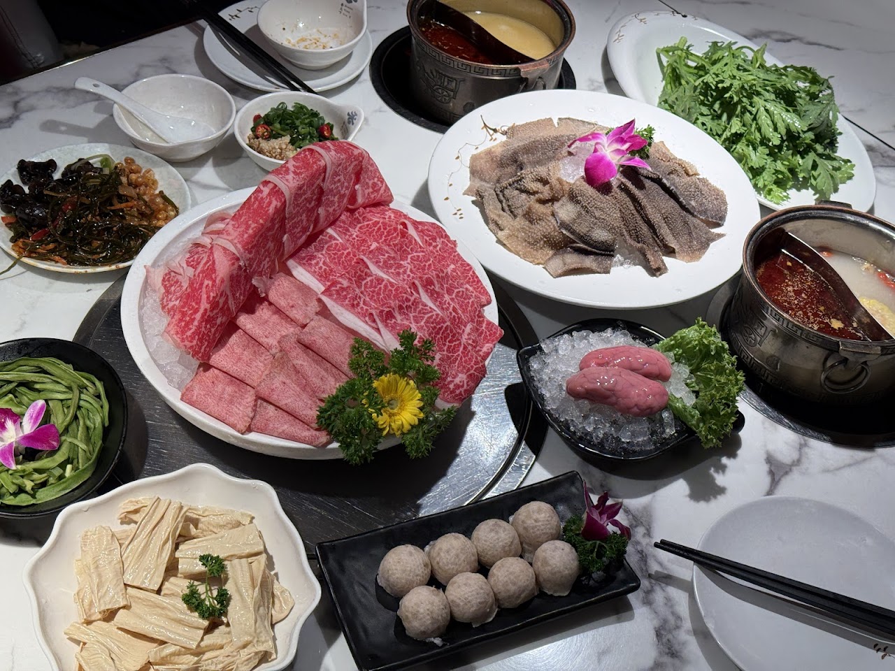 Hot pot table spread with meats and sides